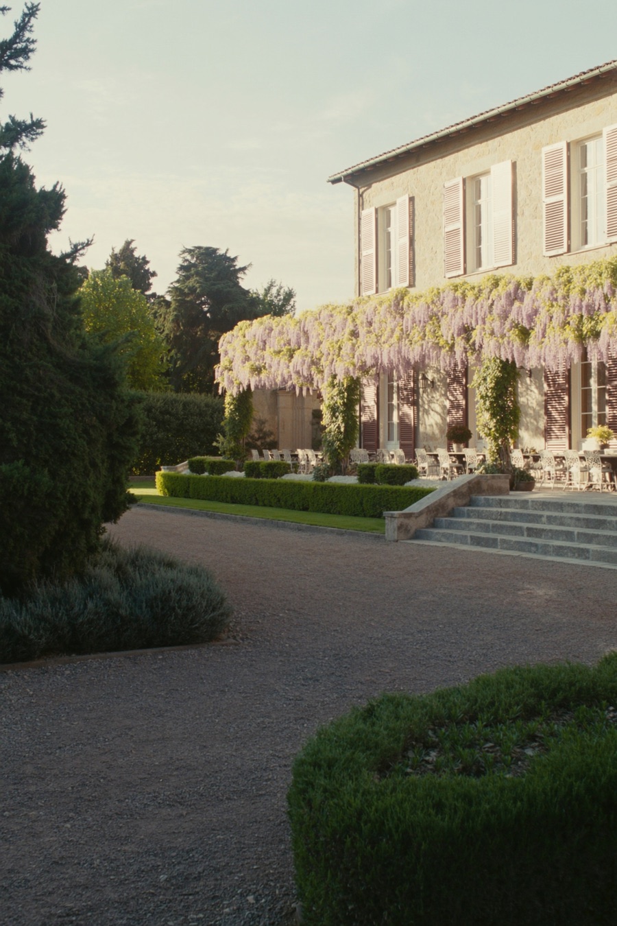 A grand villa veranda set for a large gathering at golden hour